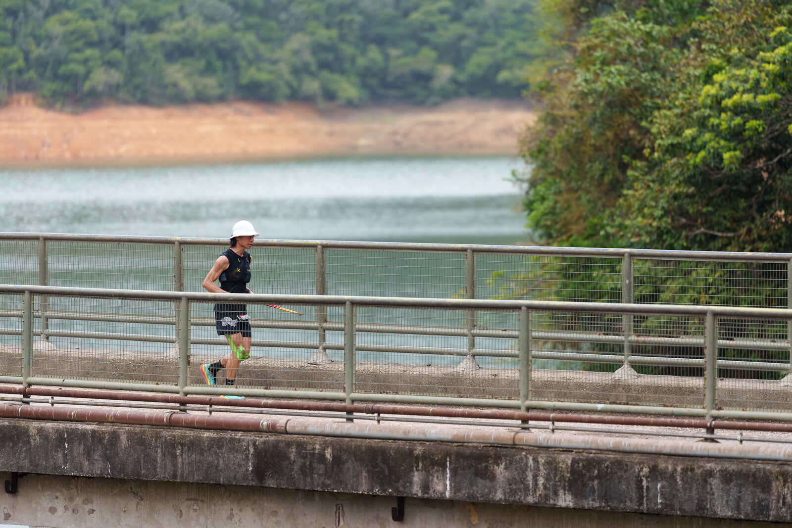 A runner crossing a reservoir bridge