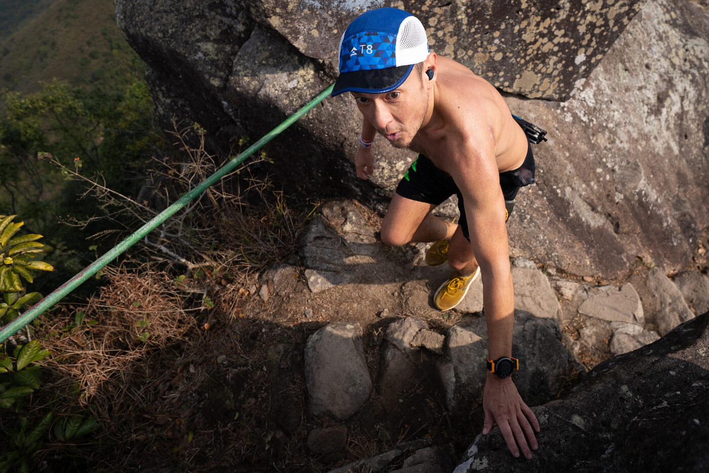Runner scrambling up a steep rock section