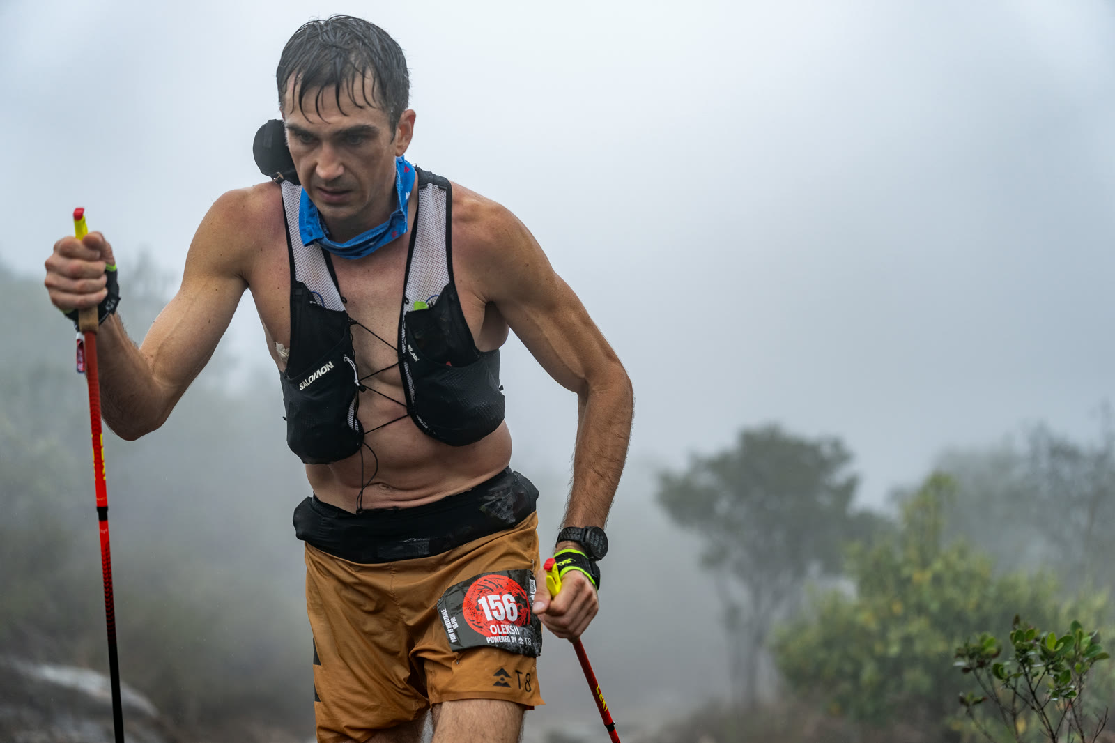 Runner with poles pushing through mist