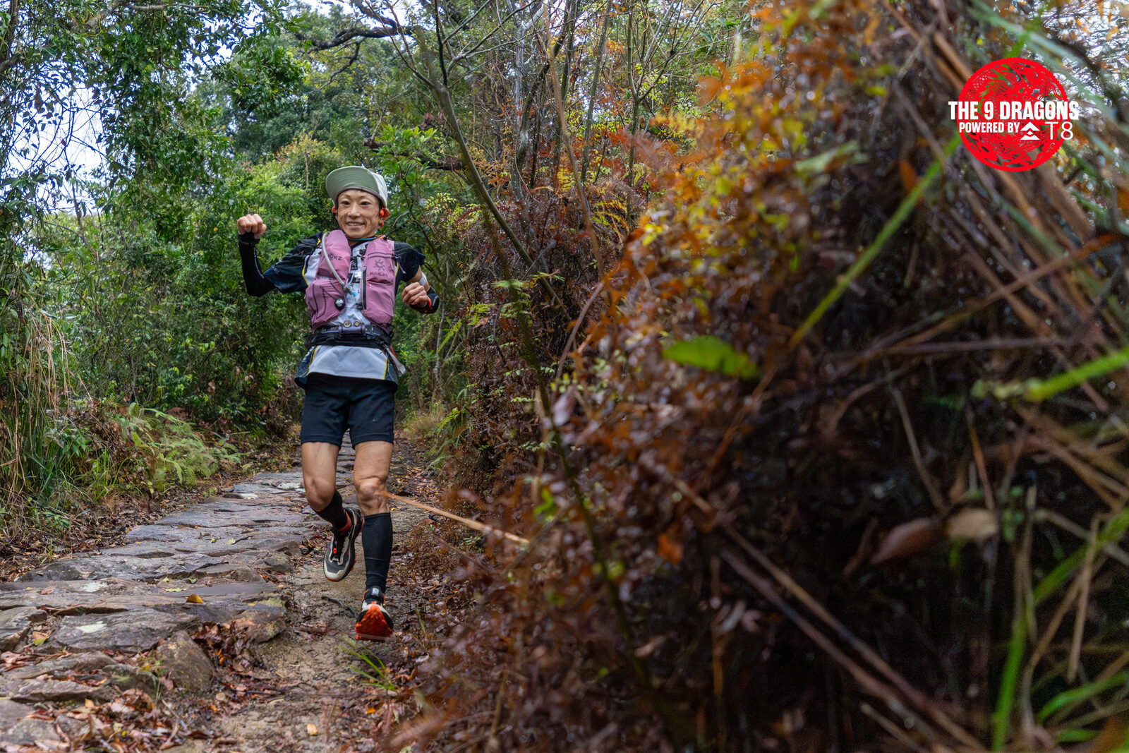 Smiling woman runner charging up a stone-stepped trail in the New Territories